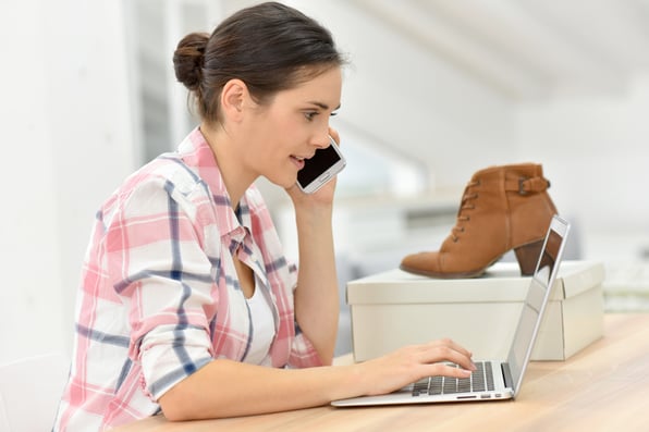 woman-on-phone-returning-shoes-to-ecommerce-brand