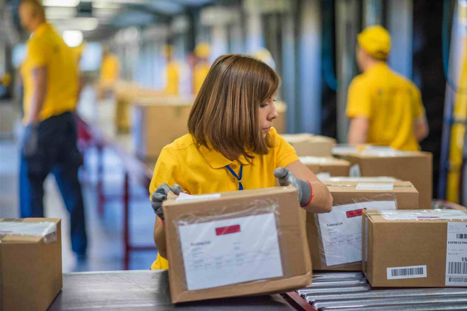 Female warehouse worker handling cardboard packages