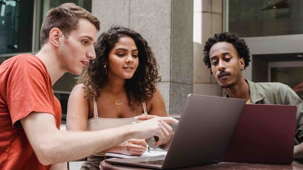 Group of multiethnic coworkers discussing startup project on laptops together