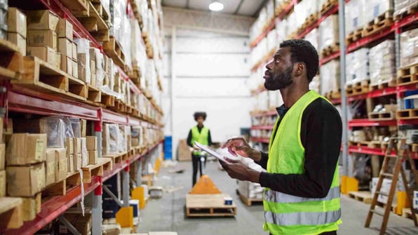 Mature warehouse worker checking inventory