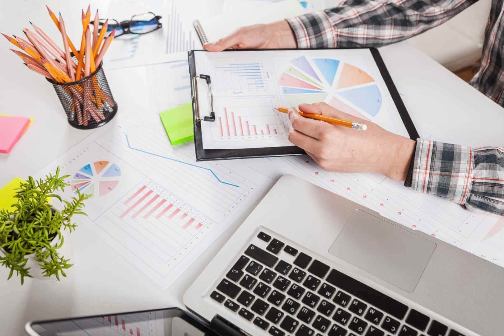 Businessman holding a pen while working with graph documents