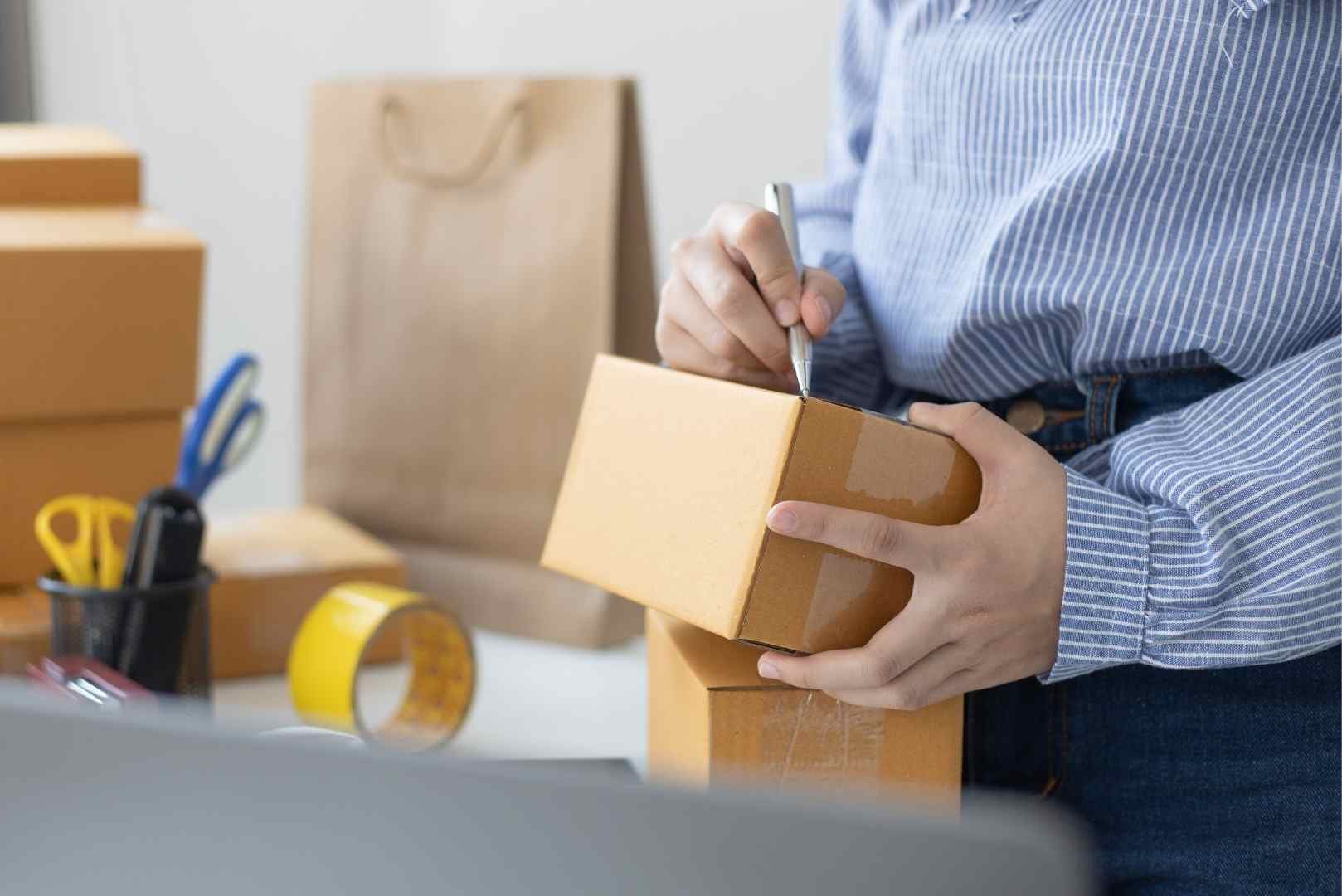 Businesswoman writing on a package