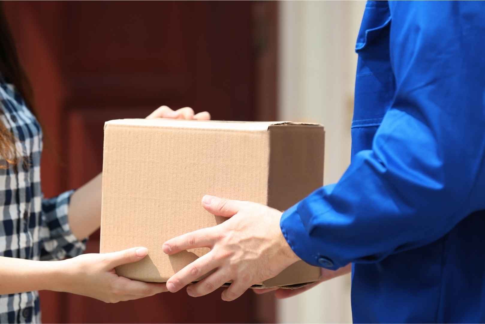 Delivery man giving the package to a woman up close