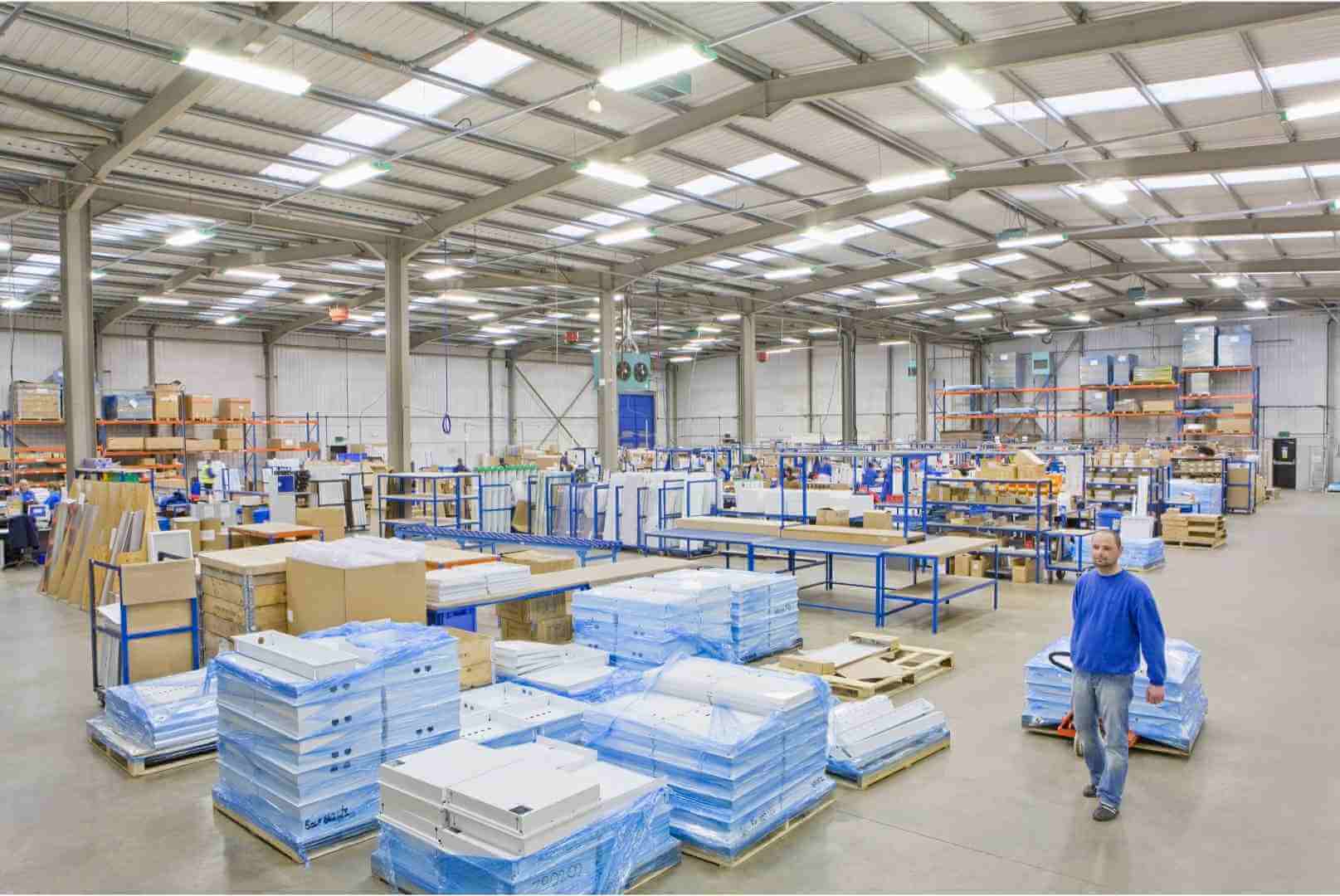 Distribution warehouse worker pulling boxes on pallet truck