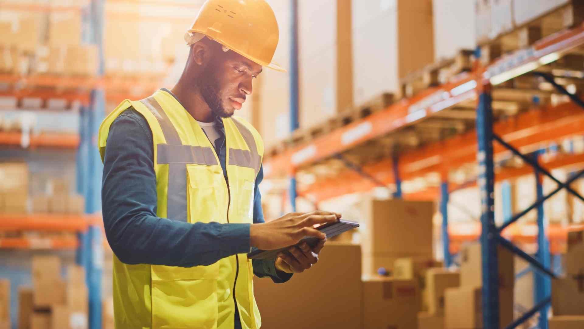 Male Worker Wearing Hard Hat Checks Products Stock and Inventory