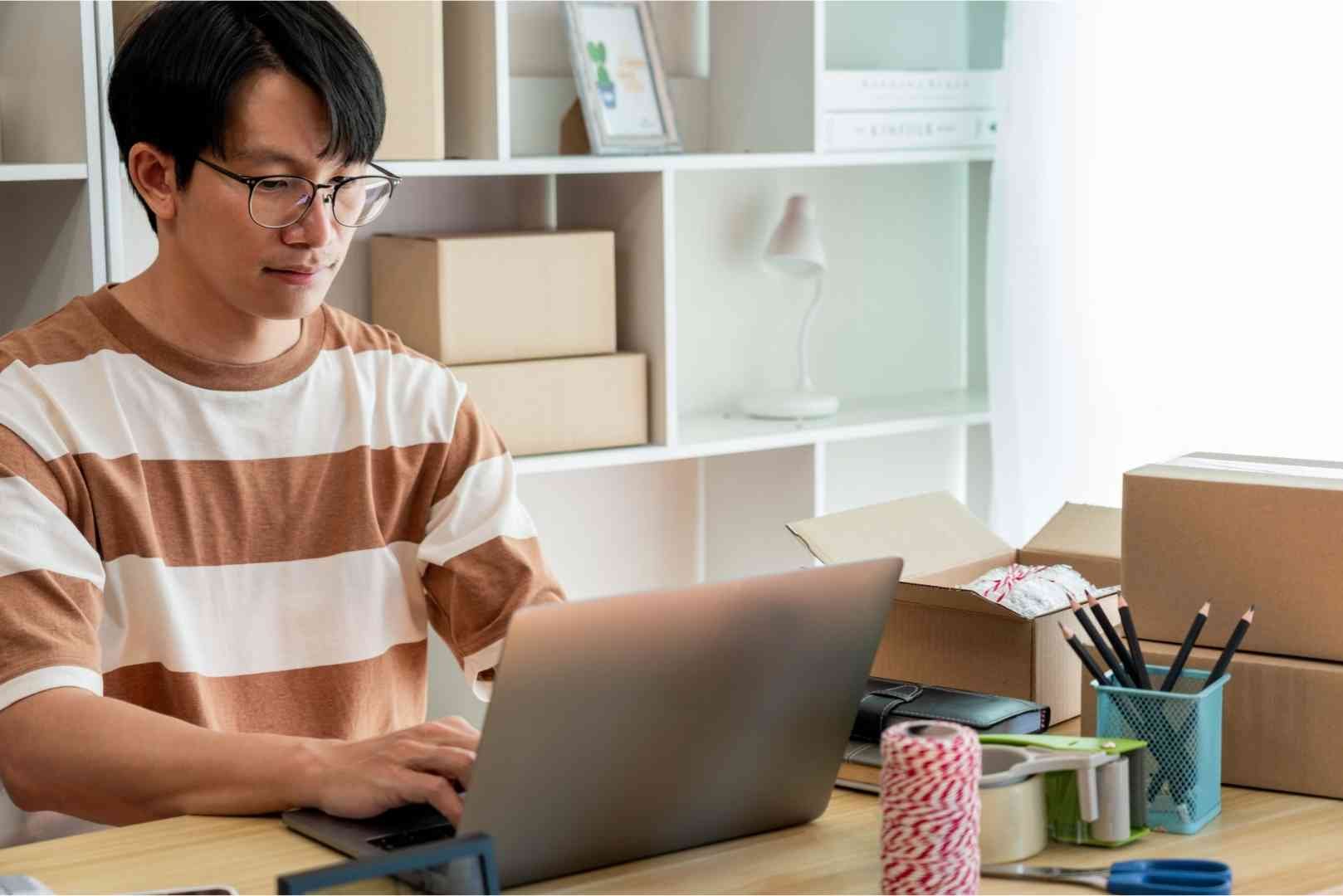 Online seller typing on his laptop