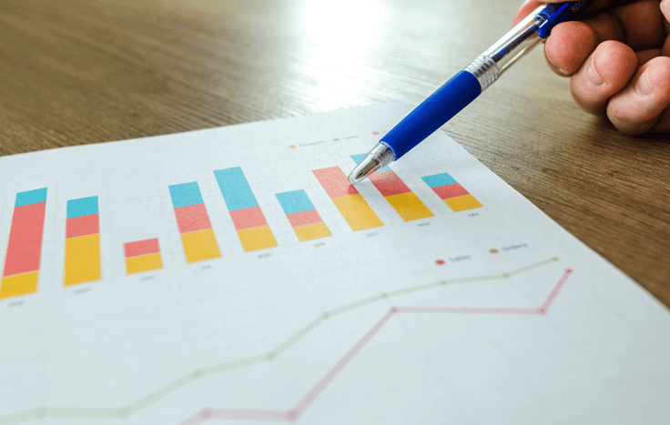 Person holding pen pointing at graph-1