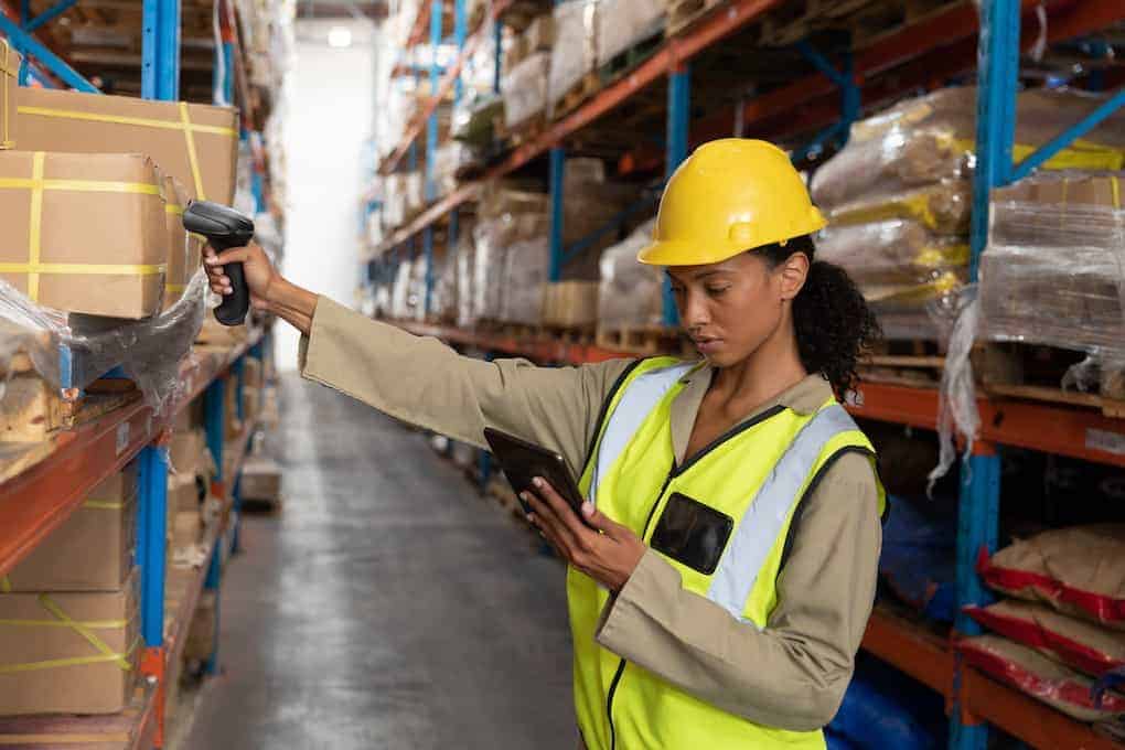 woman using inventory tracking technology inside of warehouse