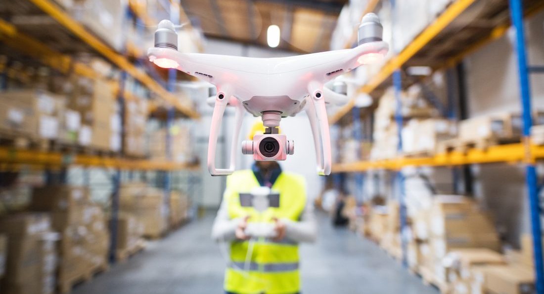 Man with drone in a warehouse.