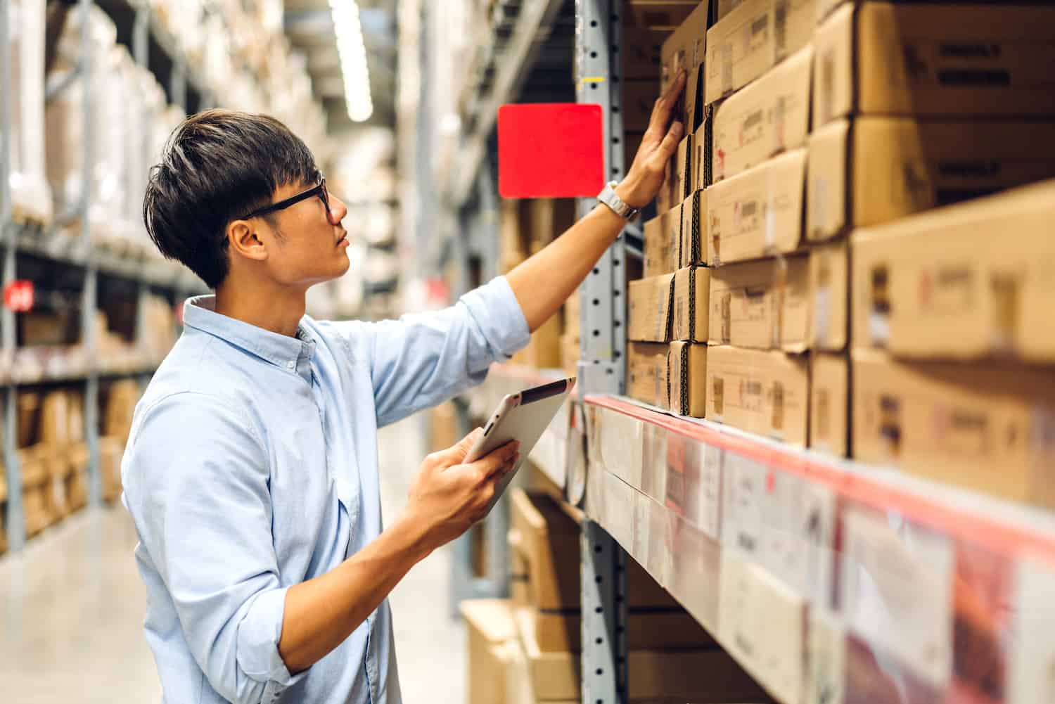 man in warehouse picks a purchase order manually from the shelf