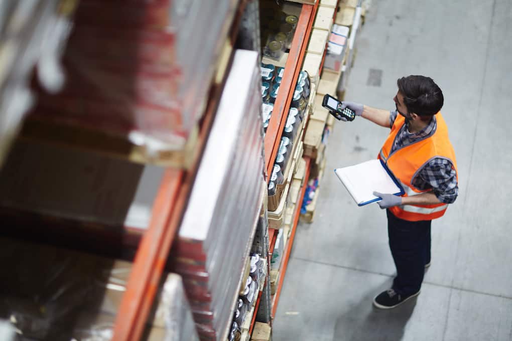 warehouse worker holding a clipboard and scanning an item