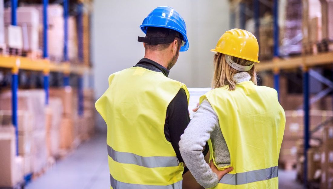 Young warehouse workers working together.