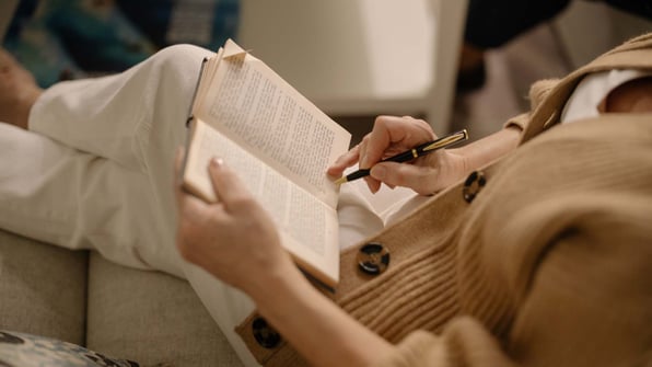 Woman on sofa reading a book