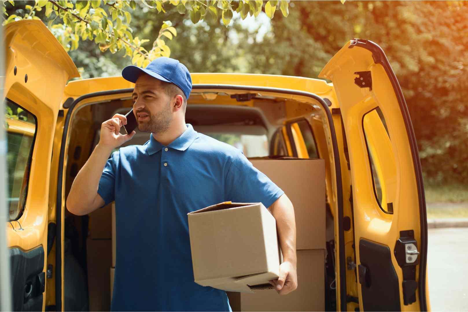 delivery worker on the phone while holding a package