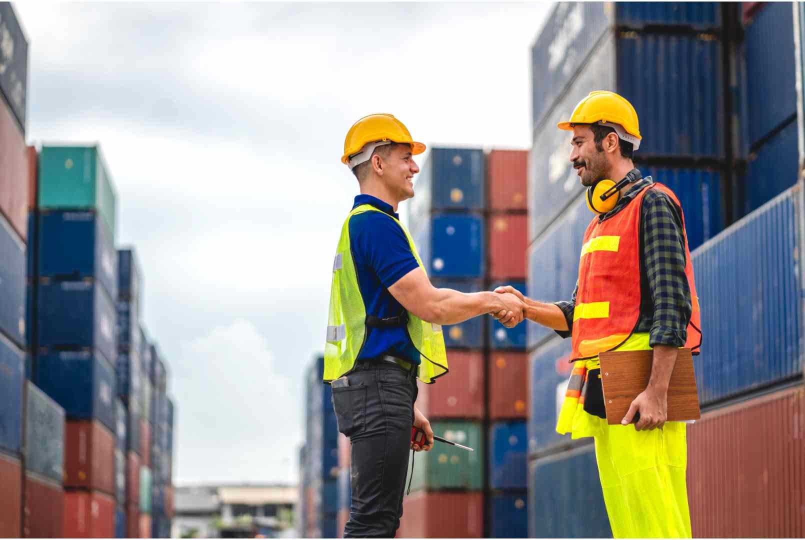 warehouse professionals shaking hands in storage area